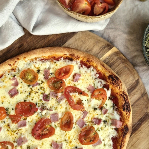 Exquisita Pizza Napoletana congelada, contiene: Salsa Pomodoro, queso mozzarella, jamón de pierna, tomate cherry y orégano.